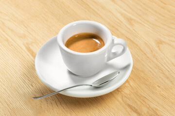 Italian Espresso Coffee Cup on wood table – Original Creamy Arabica Coffee in Traditional White Marble Cup, with Spoon, Focus on Cream – Detailed Close-Up Macro, High Resolution