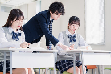 教室で先生に質問をする高校生