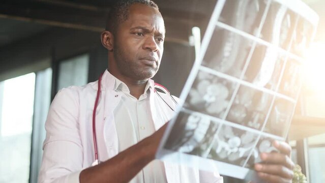 Portrait of shocked surprised scared african american man doctor therapist found something weird bad negative in diagnosis while looking at results patient MRI or CT scan procedure at office
