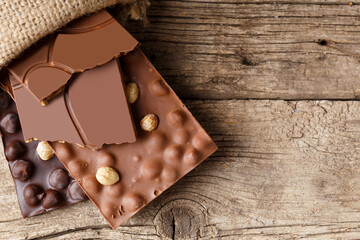 Chocolate in a burlap bag on a wooden background.