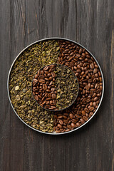 Green tea and coffee grains on a dark wooden background top view.