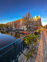 Fototapeta premium Amsterdam canal view with boats and bicycles at sunset, Netherlands