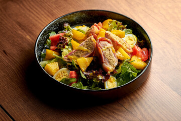 Salad with vegetables, herbs and grilled tuna. Nicoise salad. Wooden background