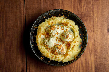 Mashed potatoes and chicken meatballs with cream sauce. Wooden background