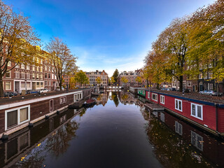 Amsterdam canal view with boats and bicycles at sunset, Netherlands
