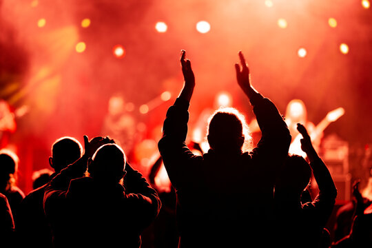 Audience and fans enjoy live music on a concert with blurry bokeh background