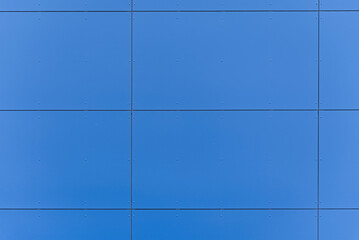 Kolorowa elewacja obiektu, budynku. Materiał z pionowych niebieskich paneli. 