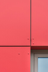 Kolorowa elewacja obiektu, budynku. Materiał z pionowych czerwonych paneli. 