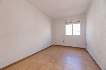 Empty room with brown stoneware floors with matching baseboards and aluminum windows