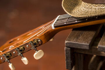 The fret of a ukulele with its strings on a wooden table