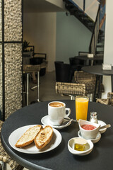 A Spanish breakfast with toasted loaf of bread with oil and tomato, coffee with milk and orange juice