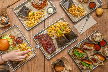 A woman's hand with fork chopping food from exposed plates