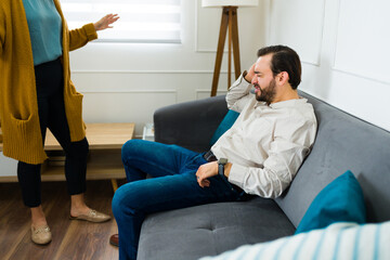 Upset man listening to her wife arguing about marriage problems