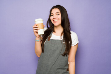 Portrait of a female barista with a coffee to go