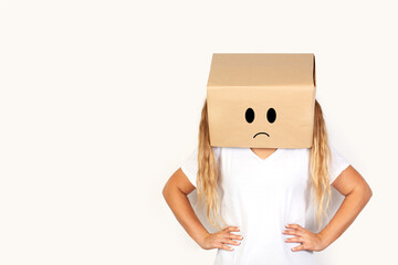 Mujer con caja de cartón en la cabeza y gesto de enfado y tristeza sobre un fondo blanco liso y aislado Vista de frente y de cerca. Copy space  - obrazy, fototapety, plakaty