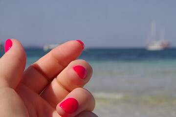 Pink nails summer style manicure,  nature background