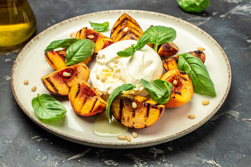 Gourmet Roasted Peaches with Burrata soft cheese, basil and drizzled with honey, with rose wine. Antipasto Dinner or aperitivo party