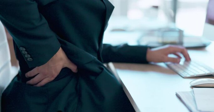 Hand, back pain and posture with a business man at his desk in the office suffering from ache or cramp. Technology, spine and anatomy with an employee sitting too long while working on a deadline