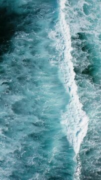 Ocean waves breaking and foaming. Aerial vertical video background