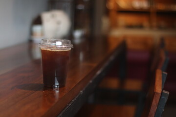 a cup of ice amaricano on the wood table