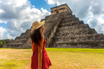 Beautiful tourist observing the old pyramid and temple of the castle of the Mayan architecture...