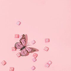 Summer spring creative pattern with pink butterfly and pink dices on pastel pink background. 80s or...