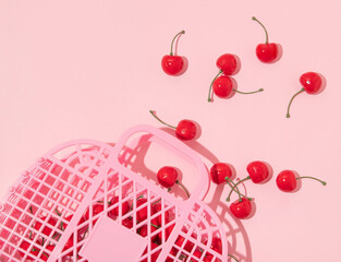 Summer creative layout pink jelly basket and cherries on pastel pink background. 80s or 90s retro fashion aesthetic love concept. Minimal romantic cosmetic idea.