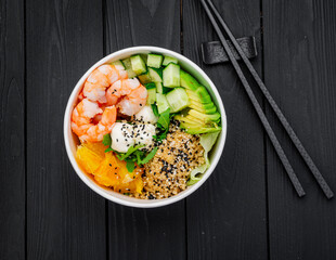 Poke bowl with shrimp, quinoa, avocado, cucumber, cream cheese and orange.