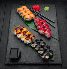 Assorted sushi nigiri and maki big set on slate. A variety of Japanese sushi with tuna, crab, salmon, eel and rolls