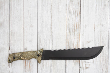 Camo machete background on weathered wood