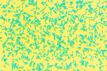 flat lay of blue sprinkles over yellow background, festive decoration for banner, poster, flyer, card, postcard, cover, brochure, designers