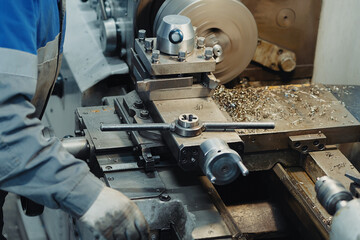 Metal turner works behind lathe in workshop. Metalworking. Background. Workplace..
