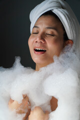 Asian woman playing with bubbles in the bathtub,body care concept