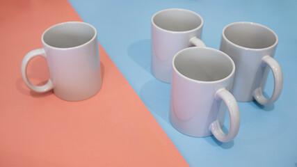 White mug on a blue and pink background. Minimalism.
