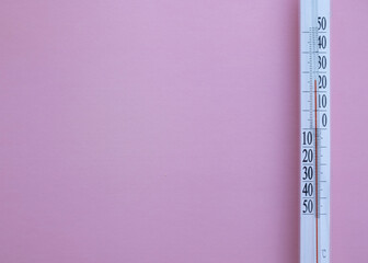Thermometer on pink background with copy space for your text.