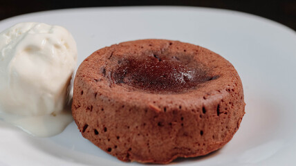 petit g?teau, chocolate fondant, dessert composed of a small chocolate cake with crunchy rind and mellow filling that is served hot with vanilla ice cream on a plate.
