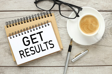 Get Results tFinance and business concept. On a wooden light background a page with text with a cup of coffee and glasses