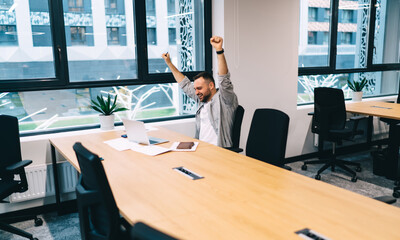 Excited man sitting in meeting room in office