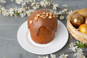 Ester cake with chocolate topping and nuts on gray background
