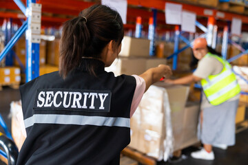 Woman security guard is catching a thief who is stealing product in large warehouse factory