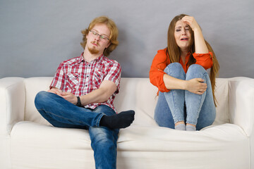 Woman and man after argue on sofa
