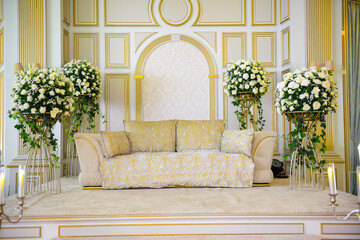 An elegantly staged traditional morocco style wedding with large sofa for the wedding couple to sit and receive blessings from the guests, 