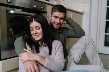 Happy man embracing woman in kitchen