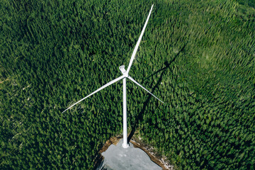 Windmills, wind turbines. Aerial view of windmills in green summer forest in Finland.
