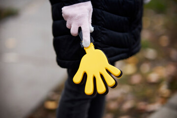 Colorful toys clap hands, plastic toy hands for applause, in the hand of a fan. Toy cracker....