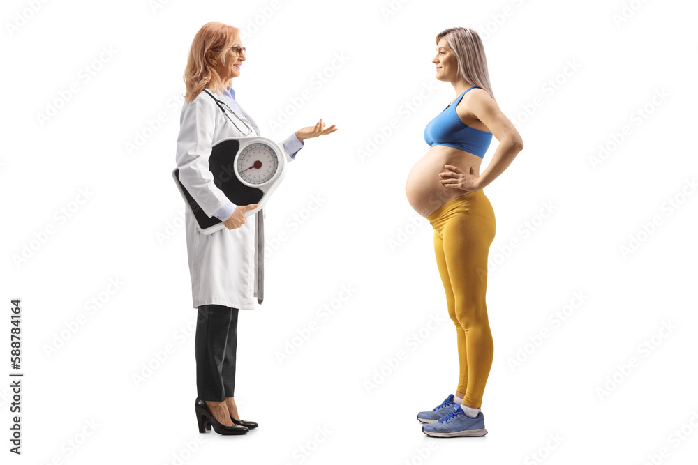 Wall mural Full length profile shot of a female doctor holding a weight scale and talking to a pregnant woman in sportswear