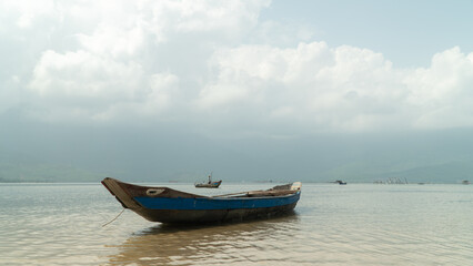 Fototapeta na wymiar Old wooden boat in the water against the sky