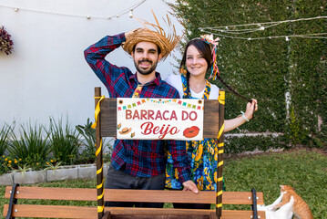 country couple celebrating in brazilian june party (festa junina). Translation: kissing tent