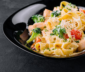italian fettuccine alfredo pasta dish with grilled salmon and broccoli