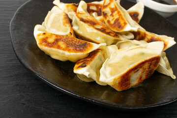 Gyoza Chinese Dumplings on Black Plate, Fried Vegetable Jiaozi Macro, Chicken Momo Pile, Asian Gyoza Closeup